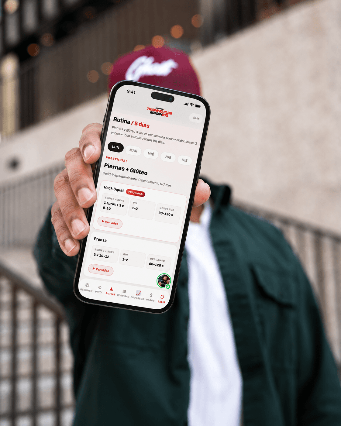 Persona mostrando la app de Braian en un celular: rutina del día con series, repeticiones y descanso